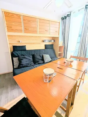 a wooden table in a room with a bed at Cocoon sur le port de Gruissan, parking & piscine in Gruissan