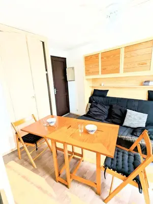 a dining room with a table and a couch at Cocoon sur le port de Gruissan, parking & piscine in Gruissan