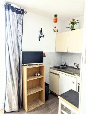 a small kitchen with a sink and a microwave at Cocoon sur le port de Gruissan, parking & piscine in Gruissan