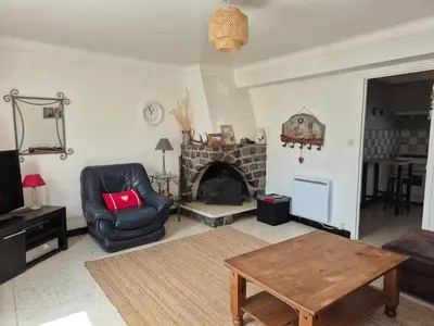a living room with a chair and a fireplace at La Maison de Léonie in Camurac