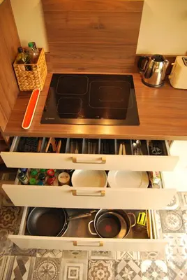 a kitchen with a stove top oven sitting inside of a cabinet at Gruissan Terrasse jardin cosy et au calme in Gruissan