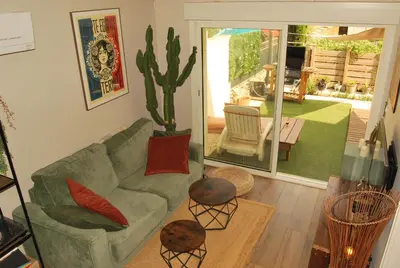 a living room with a green couch and a cactus at Gruissan Terrasse jardin cosy et au calme in Gruissan