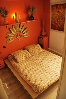 a bedroom with a bed with an orange wall at Gruissan Terrasse jardin cosy et au calme in Gruissan