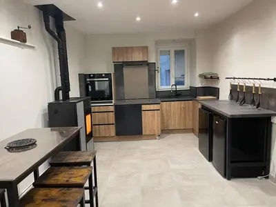 a large kitchen with black appliances and wooden cabinets at Maison gorges de la Pierre lys in Belvianes-et-Cavirac