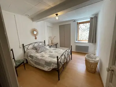 a bedroom with a bed and a window at Maison gorges de la Pierre lys in Belvianes-et-Cavirac