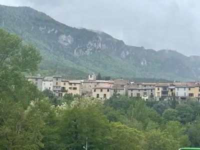 a group of buildings in front of a mountain at Maison gorges de la Pierre lys in Belvianes-et-Cavirac
