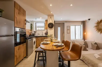 a kitchen and living room with a table and a couch at L'Opale - Duplex Calme & Confort en Hypercentre in Castres