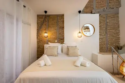 a bedroom with a large bed with white pillows at L'Opale - Duplex Calme & Confort en Hypercentre in Castres