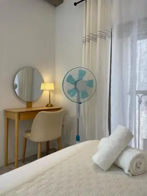 a bedroom with a bed with a fan and a desk at L'Opale - Duplex Calme & Confort en Hypercentre in Castres