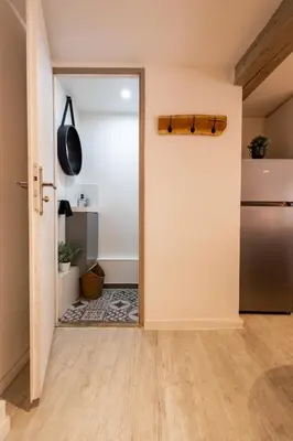 an open door into a kitchen with a refrigerator at L'Opale - Duplex Calme & Confort en Hypercentre in Castres