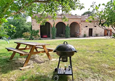 a living room with a couch and a wooden wheel at Grand gîte de charme 190 m2 avec billard, jardin et cheminée- idéal familles ou entre amis - proche Canal du Midi in Lagarde