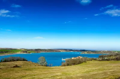 a view of a lake with a house on a hill at Grand gîte de charme 190 m2 avec billard, jardin et cheminée- idéal familles ou entre amis - proche Canal du Midi in Lagarde