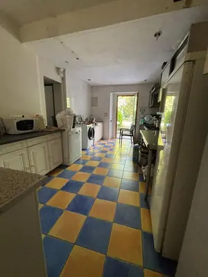 a kitchen with a blue and yellow checkered floor at Château Belle au Bois Dormant in Cambounet-sur-le-Sor