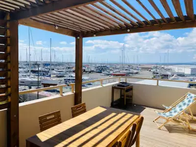 a balcony with a table and a view of a harbor at T3 with large roof-top terrace, harbor view in Gruissan