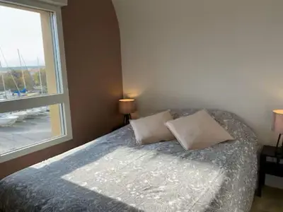 a bedroom with a bed with two pillows and a window at T3 with large roof-top terrace, harbor view in Gruissan