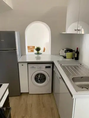 a kitchen with a washing machine and a sink at T3 with large roof-top terrace, harbor view in Gruissan