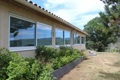 a house with windows on the side of it at Au Cammazou in Villanière