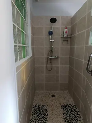 a bathroom with a shower with a tiled floor at Au Cammazou in Villanière