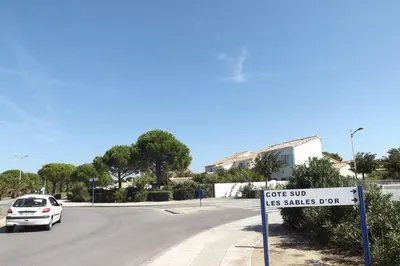 a white car driving down a street with a sign at Villa à Gruissan Mateille avec petit jardin et terrasse couverte in Gruissan