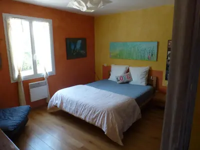 a bedroom with a bed with orange walls at Maison de vacances avec piscine en bord de mer in Lapalme
