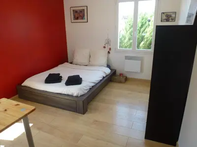 a bedroom with a bed with two black towels on it at Maison de vacances avec piscine en bord de mer in Lapalme
