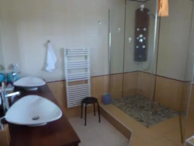 a bathroom with a shower and a sink and a stool at Maison de vacances avec piscine en bord de mer in Lapalme