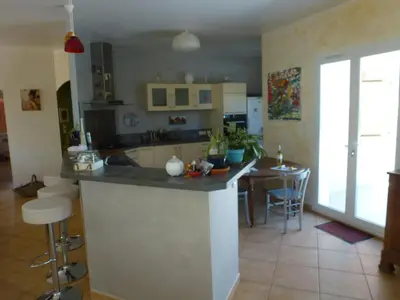 a kitchen with a island in the middle of a room at Maison de vacances avec piscine en bord de mer in Lapalme