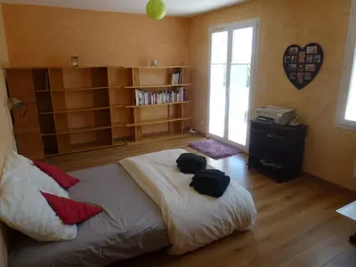 a bedroom with a bed with pillows and a book shelf at Maison de vacances avec piscine en bord de mer in Lapalme