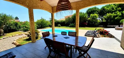 a patio with a table and chairs and a swimming pool at Maison de vacances avec piscine en bord de mer in Lapalme