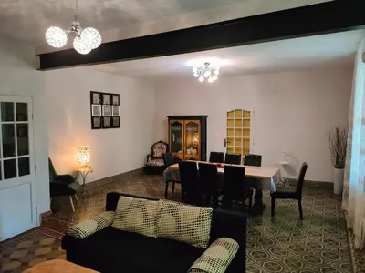 a living room with a table and chairs at La maison gourmande in Alzonne