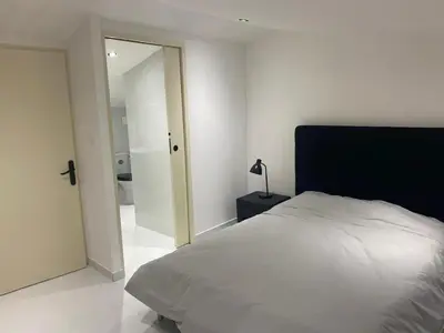 a bedroom with a white bed and a mirror at Maison accueillante à Trèbes avec 2 chambres in Trèbes