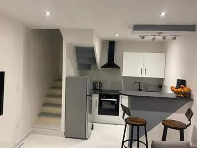 a kitchen with a counter and some stools in it at Maison accueillante à Trèbes avec 2 chambres in Trèbes