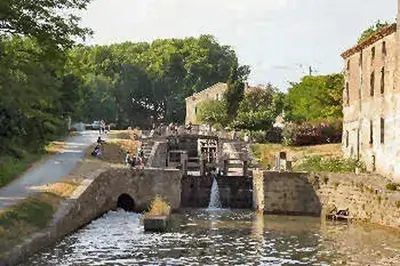 a bridge over a river with a water fountain at Maison accueillante à Trèbes avec 2 chambres in Trèbes