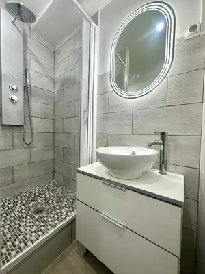 a white bathroom with a sink and a shower at Jolie 2 pièces centre ville in Narbonne