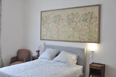 a bedroom with a bed and a large painting on the wall at Relais des Vignerons, Chambres d'hôtes in Conilhac-Corbières