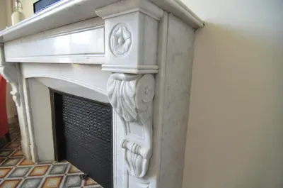 a fireplace with a white mantel on a wall at Relais des Vignerons, Chambres d'hôtes in Conilhac-Corbières