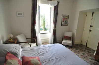 a bedroom with a bed and a window at Relais des Vignerons, Chambres d'hôtes in Conilhac-Corbières
