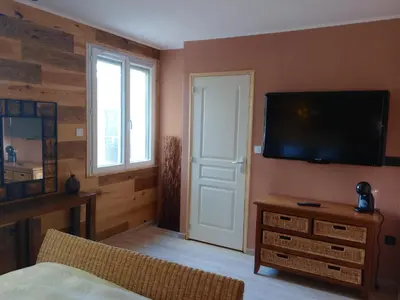 a bedroom with a flat screen tv on a wall at chambre et table d'hôte au coin de la cité in Carcassonne