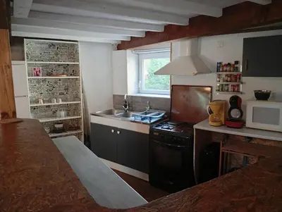 a kitchen with a sink and a stove and a microwave at Appartement prémian in Prémian