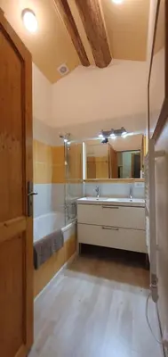 a bathroom with a tub and a sink and a mirror at Les Quatre Saisons in Montaillou