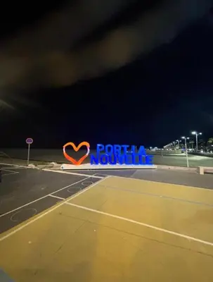 a sign with a heart on the side of a tennis court at Charmant T2 à 1 min de la plage in Port-la-Nouvelle