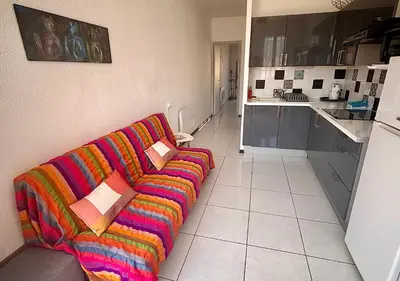 a living room with a colorful couch in a kitchen at Charmant T2 à 1 min de la plage in Port-la-Nouvelle