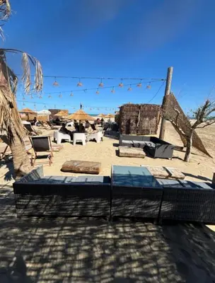 two beds on a beach with chairs and umbrellas at Charmant T2 à 1 min de la plage in Port-la-Nouvelle
