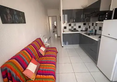 a living room with a colorful couch in a kitchen at Charmant T2 à 1 min de la plage in Port-la-Nouvelle