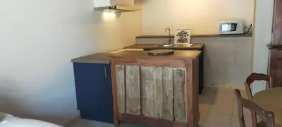 a kitchen with a wooden island in a room at De l'étang de BAGES au massif de la Clape in Narbonne