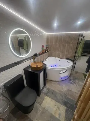 a bathroom with a tub and a chair and a mirror at Tanabata logde in Pezens
