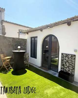 a patio with a green lawn in front of a house at Tanabata logde in Pezens