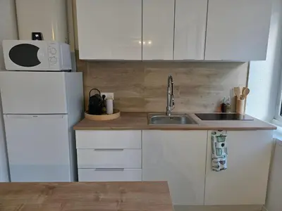 a small kitchen with a sink and a refrigerator at Studio hypercentre in Castelnaudary