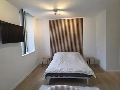 a bed in a room with two chairs and a window at Studio hypercentre in Castelnaudary