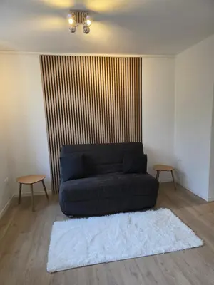 a living room with a blue couch and two tables at Studio hypercentre in Castelnaudary
